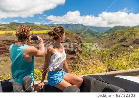 Road trip vacation car couple taking pictures of Hawaii nature 68722303