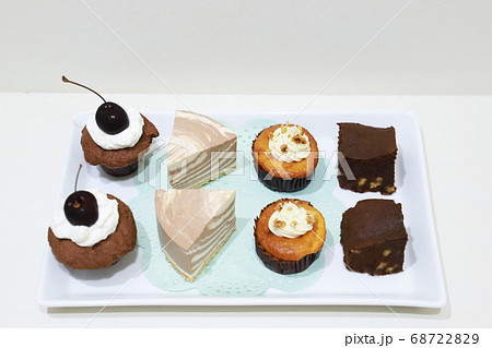 白いお皿のプチケーキ カップケーキ ブラウニー 人参ケーキ チーズケーキの写真素材