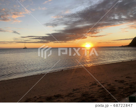 ビーチでのオレンジ色の太陽のサンセットの写真素材