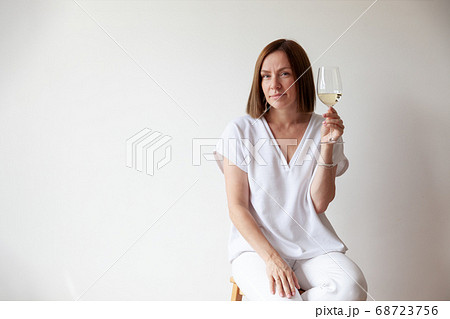 Caucasian brunette girl sommelier holding glass of white wine Caucasian brunette girl sommelier holding glass of white wine 68723756