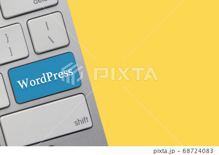 WORDPRESS text on keyboard over yellow background. 68724083