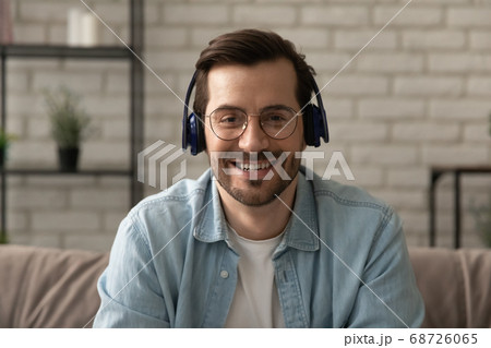 Headshot portrait of man in headphones talk on video call Headshot portrait of man in headphones talk on video call 68726065