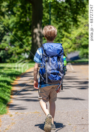 Boy hiking in the park with huge rucksack 68727247