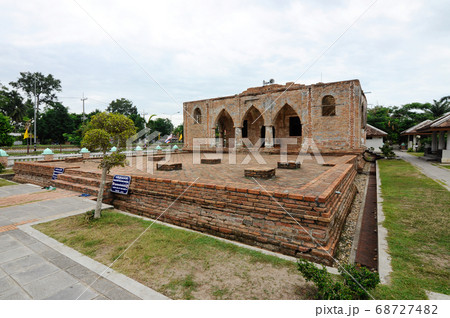 PATTANI, THAILAND -JULY 10, 2019: Historic Kru Se mosque which is made of bricks with round pillars. The mosque represents a unique Islamic civilization of the Kingdom of Pattani in Thailand. 68727482