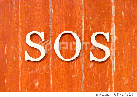 Alphabet letter in word SOS (abbreviation of save our soul/ship or sibling over shoulder) on old red color wood plate background 68727519