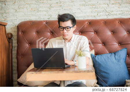 Modern business man using laptop on wood table 68727824