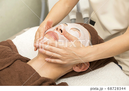 フェイスパックをするエステティシャン　メンズエステ　脱毛イメージ　メンズ髭脱毛 68728344