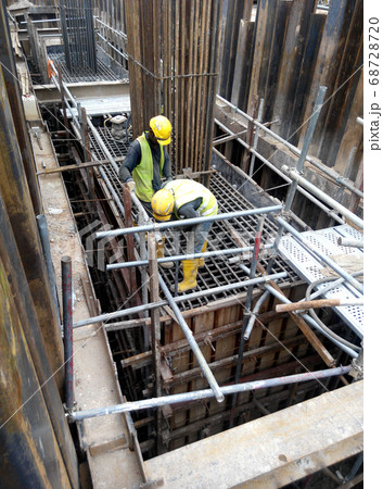 MALACCA, MALAYSIA -MAY 27, 2016: Construction workers fabricating steel reinforcement bar at the construction site in Malacca, Malaysia. The reinforcement bar was ties together using tiny wire.   68728720