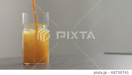 sea buckthorn juice pour into beaker glass with water on concrete surface sea buckthorn juice pour into beaker glass with water on concrete surface 68730741