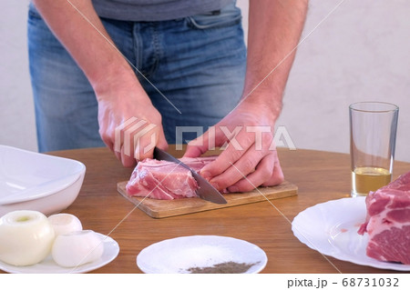 Man cutting fresh fillet meat pork on pieces to cook shashlik, hands closeup. Man cutting fresh fillet meat pork on pieces to cook shashlik, hands closeup. 68731032