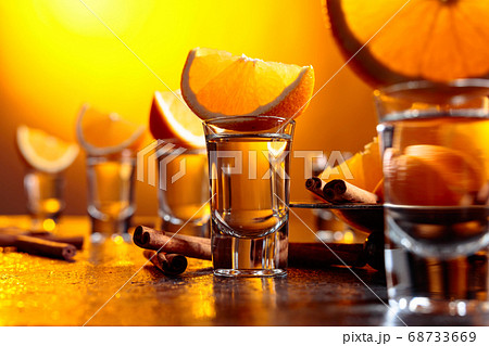 Glasses of tequila with orange and cinnamon 68733669