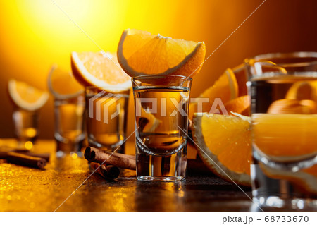 Glasses of tequila with orange and cinnamon 68733670