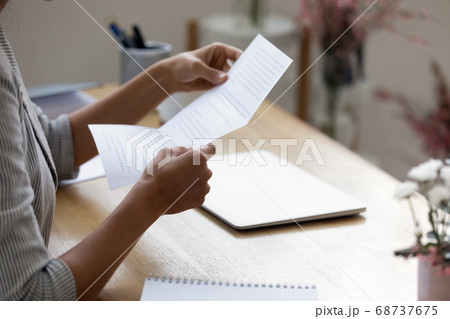 Close up young woman holding paper letter with good news. Close up young woman holding paper letter with good news. 68737675