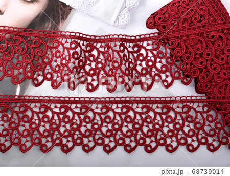Tapes of red vinous gentle guipure, beauty lace fabric on light background Tapes of red vinous gentle guipure, beauty lace fabric on light background 68739014