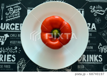 Red bell pepper on white food plate on black Red bell pepper on white food plate on black 68740197