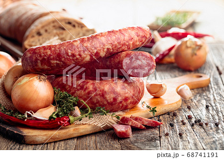 Dry-cured sausage with bread and spices on a old Dry-cured sausage with bread and spices on a old 68741191