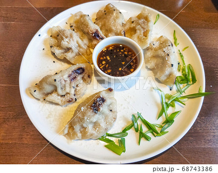 Asian fried dumplings with soy sauce on a plate and greens Asian fried dumplings with soy sauce on a plate and greens 68743386