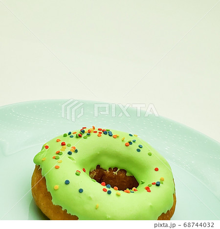 Donut with green icing on a blue plate 68744032