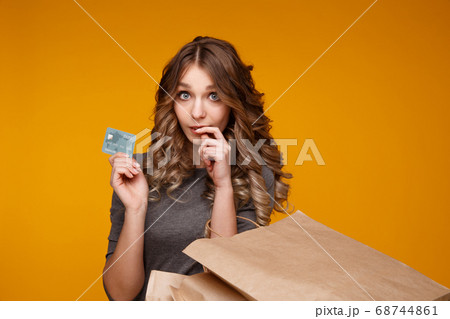 Young beautiful woman holding shopping bags and a credit card Young beautiful woman holding shopping bags and a credit card 68744861