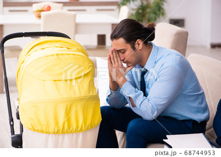 Young businessman looking after newborn at home 68744953