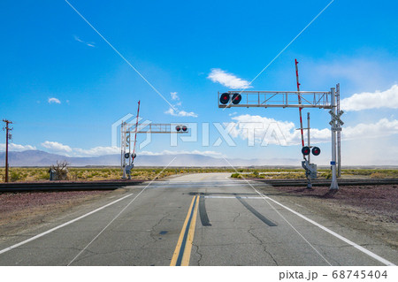Railroad crossing gates on a road in the Mojave Desert Railroad crossing gates on a road in the Mojave Desert 68745404