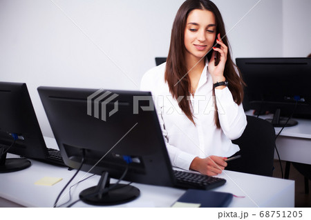 Woman sitting at desk, working on laptop in modern office Woman sitting at desk, working on laptop in modern office 68751205
