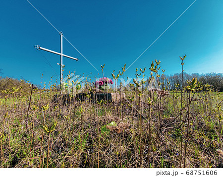Aged cross tomb with flowers and overgrown grass. wake old christian traditional Aged cross tomb with flowers and overgrown grass. wake old christian traditional 68751606