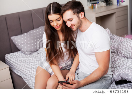 Happy couple having fun in bed. Intimate sensual young couple in bedroom enjoying each other Happy couple having fun in bed. Intimate sensual young couple in bedroom enjoying each other 68752193