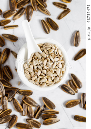 Sunflower seeds in white small bowl Sunflower seeds in white small bowl 68755471