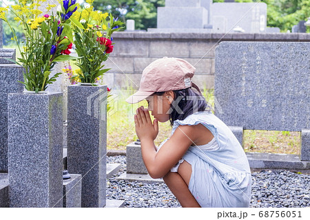 お墓参り　墓前で手を合わせて黙とうする女の子 68756051