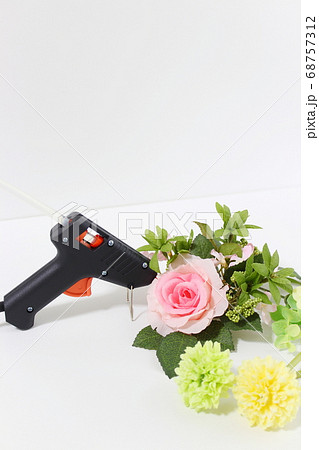 グルーガンで造花をくっつける ハンドメイド 手芸イメージ 白背景 コピースペース の写真素材