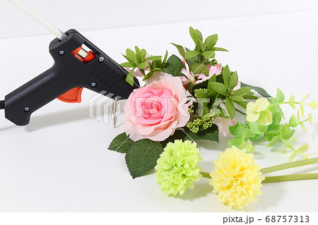 グルーガンで造花をくっつける【ハンドメイド・手芸イメージ】【白背景・アップ】 グルーガンで造花をくっつける【ハンドメイド・手芸イメージ】【白背景・アップ】 68757313