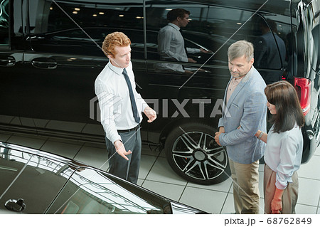 Middle aged consumers in smart casualwear listening to young sales manager 68762849