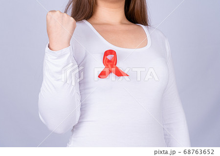 Red AIDS awareness ribbon on woman chest and raise 68763652