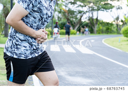 Asian man suffering from stomach ache while Asian man suffering from stomach ache while 68763745