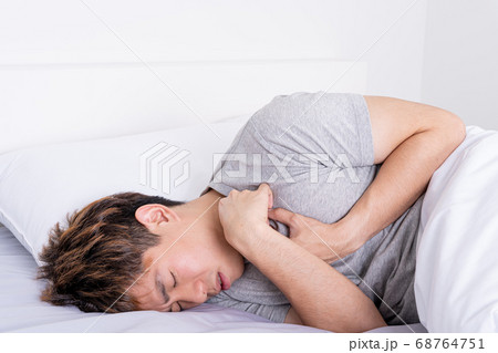 Young man suffering from chest pain after wake up Young man suffering from chest pain after wake up 68764751