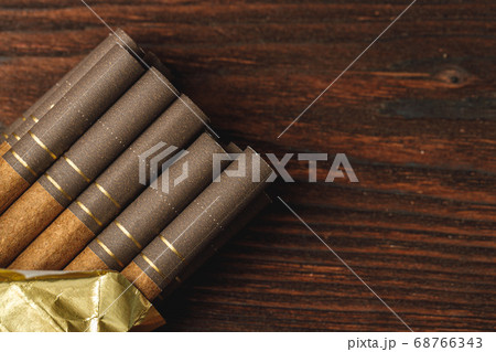 Pack of cigarettes close up on wooden background 68766343