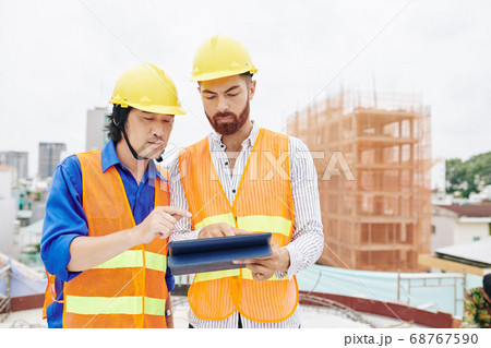 Contractor and builder discussing work schedule 68767590