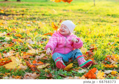 Happy young girl playing under falling yellow Happy young girl playing under falling yellow 68768373