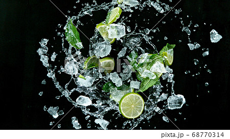 Fresh ripe limes flying on a black background. Fresh ripe limes flying on a black background. 68770314