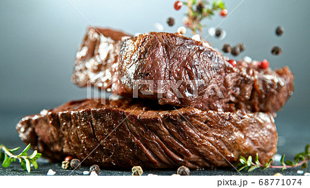Close-up of tasty beef steak on stone table Close-up of tasty beef steak on stone table 68771074