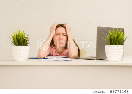 Tired overworked young intern woman working with a 68771148