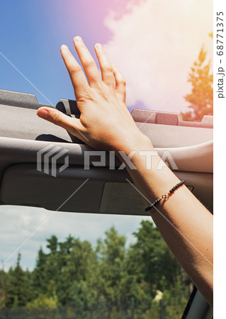 Feminine hand out from open hatch of a vehicle on sunny day. Feminine hand out from open hatch of a vehicle on sunny day. 68771375