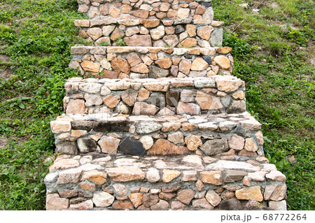 Stone staircase upward on green grass background 68772264