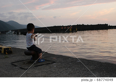 夕暮れの港で堤防釣りをする男の子 幼児 の写真素材