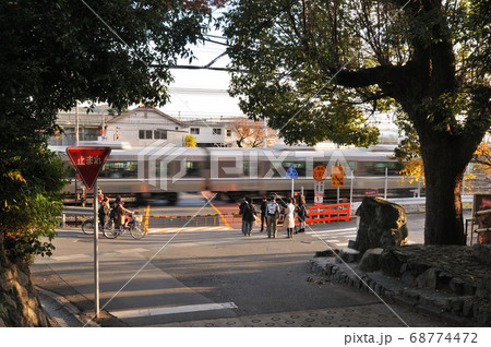 踏切で列車の通過をする日常風景の写真素材