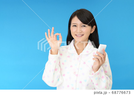 スマートフォンを持つ笑顔の女性 スマートフォンを持つ笑顔の女性 68776673