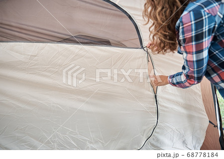 Woman setting up camping tent at the forest 68778184