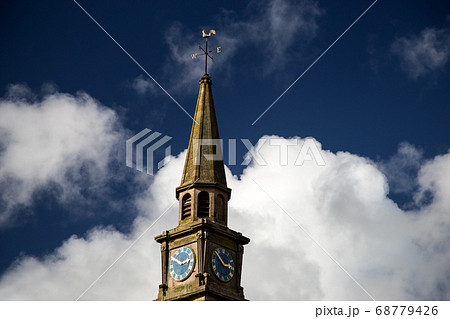 Church Steeple and Clock Against a Blue Cloudy Sky 68779426