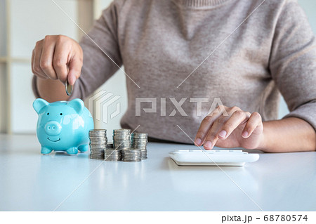 Young woman putting coins into piggy bank planning 68780574